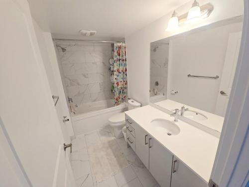 a white bathroom with a sink and a toilet at Downsview Park Retreat 1 - Rogers Stadium Getaway in Toronto