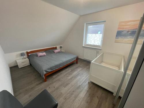 a small bedroom with a bed and a window at Am Wangermeer 38a in Wangerland