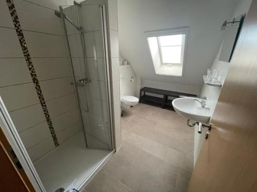 a bathroom with a shower and a toilet and a sink at Am Wangermeer 38a in Wangerland