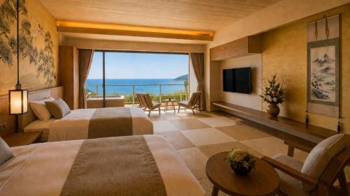 a hotel room with two beds and a view of the ocean at 카미소 in Tsushima