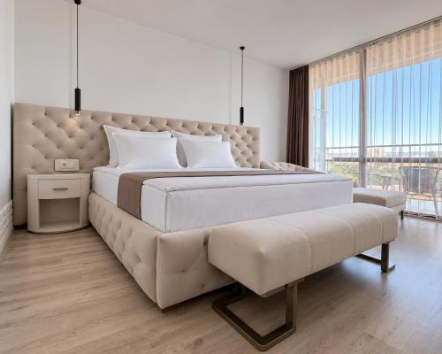 a bedroom with a large bed and a couch at Hotel Jupiter in Sunny Beach