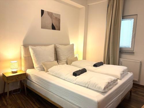 a bed with two pillows on it in a room at City Loft Traum Quartier Apartments in Siegen