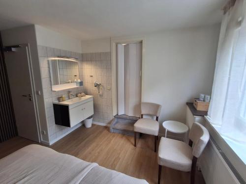 a bedroom with a bathroom with a sink and a mirror at B&B Haus Valmosa in Valwig
