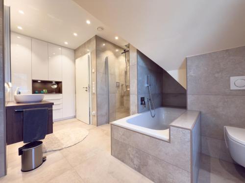 a bathroom with a tub and a toilet and a sink at Haus Strandhafer in Wangerland