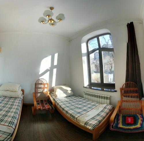 a room with two beds and two chairs and a window at Hostel MIF in Ivano-Frankivsʼk