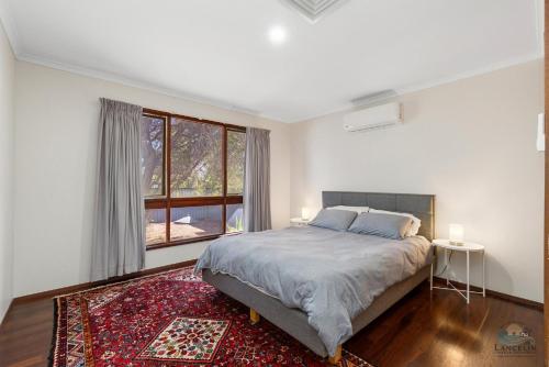 a bedroom with a bed and a large window at The Newby in Lancelin