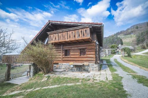 a small wooden house on a hill with a road at Home in Heaven I Historical Log House in Šentrupert