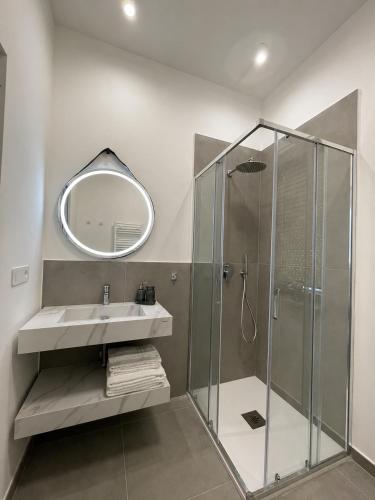 a bathroom with a shower and a sink and a mirror at Moon Apartments A in Soverato Marina