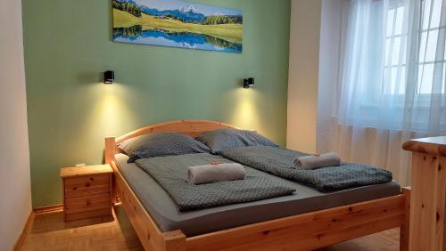 a bedroom with a wooden bed with two pillows on it at Das Eckhaus in Murau
