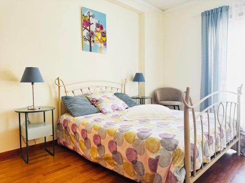 a bedroom with a bed and two chairs and a window at Cavado Pool Apartment in Fão