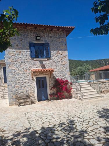 a stone building with a blue window and a door at villa olivedream in Nea Epidavros