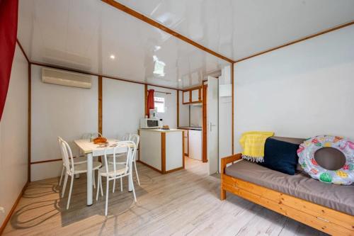 a living room with a couch and a table with chairs at Camping 4 étoiles - Piscine - ccbfhbf in Badefols-sur-Dordogne
