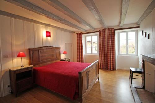 a bedroom with a large bed with a red bedspread at Les bonnes fontaines in Cieux
