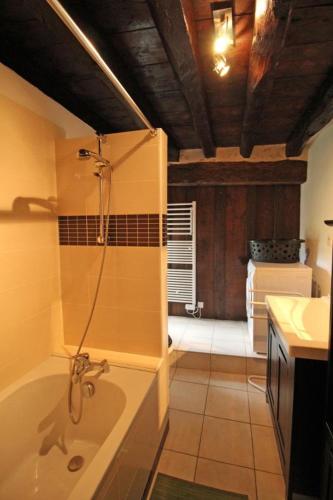 a bathroom with a tub and a sink at Les bonnes fontaines in Cieux