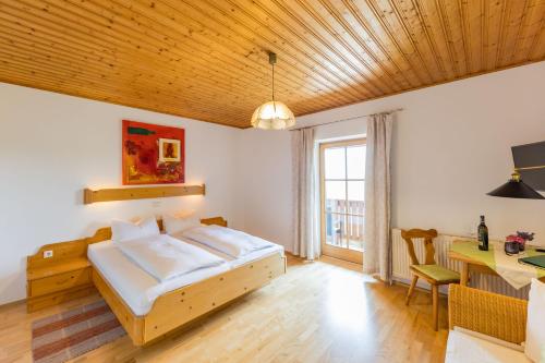 a bedroom with a bed and a desk and a table at Weingut Peter Skoff - Domäne Kranachberg in Gamlitz