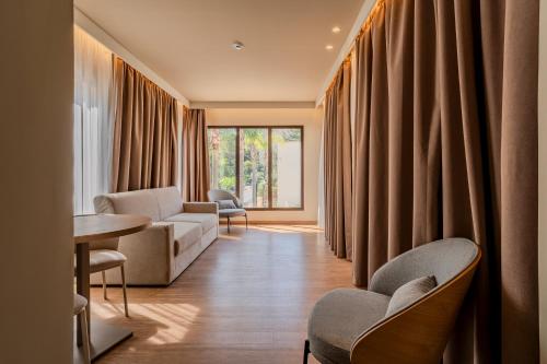 a waiting room with chairs and a table and curtains at Modica Inn Centro, BW Premier Collection in Modica