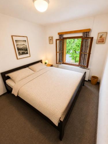 a bedroom with a large bed and a window at Chata Návrší in Stříbrnice