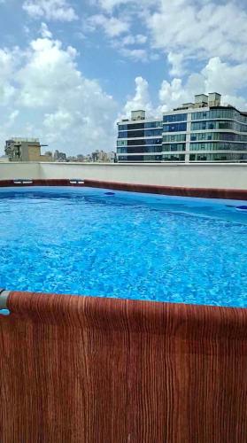 a large swimming pool in front of a building at Sunset Home - Netanya Roof & Sea View in Netanya