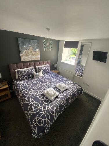 a bedroom with a bed with a blue and white comforter at Mossie Apartment in Ayr