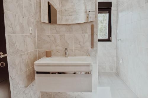 a white bathroom with a sink and a shower at Casa ZOMABRIA in Poreč