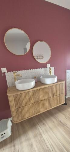 a bathroom with two sinks and two mirrors at Duplex Le Trèfle in Charmes-sur-lʼHerbasse