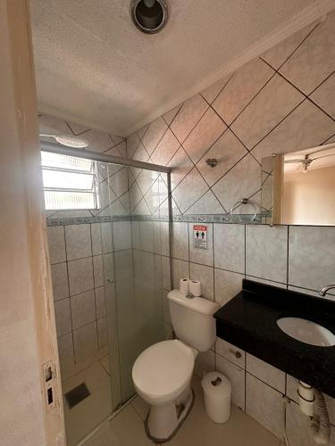 a bathroom with a toilet and a sink at Pousada Saturnino in Hortolândia