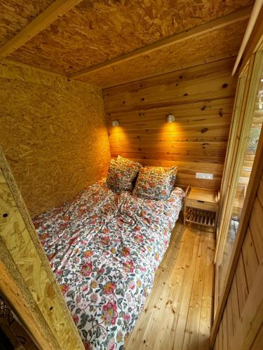 a bed in a room with a wooden wall at L'Écrin du Neudorf in Strasbourg