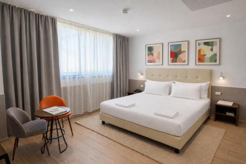 a bedroom with a large white bed and a chair at Lh HOTELS in Milan