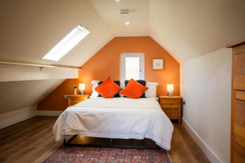 a bedroom with orange walls and a bed with orange pillows at Cosy Hideaway I Couples Break I Private Estate in Newborough