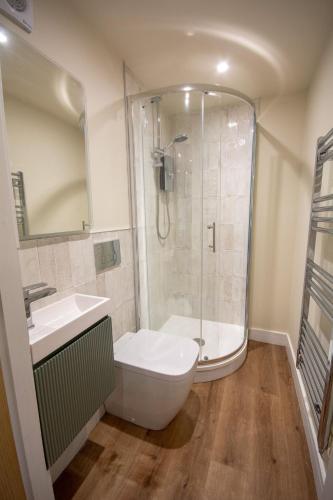 a bathroom with a shower and a toilet and a sink at Cosy Hideaway I Couples Break I Private Estate in Newborough