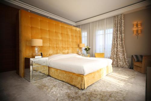 a bedroom with a large bed with a large headboard at Villa Cœur de Mer in Nice