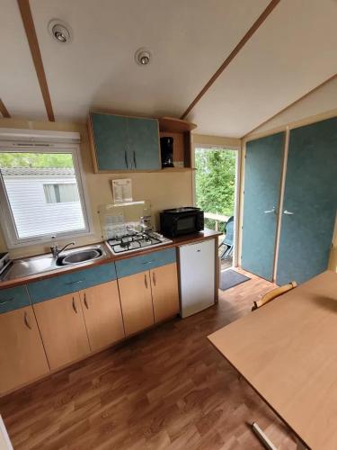 a small kitchen with a sink and a stove at Camping 3 étoiles - Piscine - ccbfi0e in Mauroux