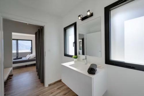a white bathroom with a sink and a mirror at Villa Bamboo in Lathuile