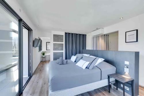 a bedroom with a large blue bed and a window at Villa Bamboo in Lathuile