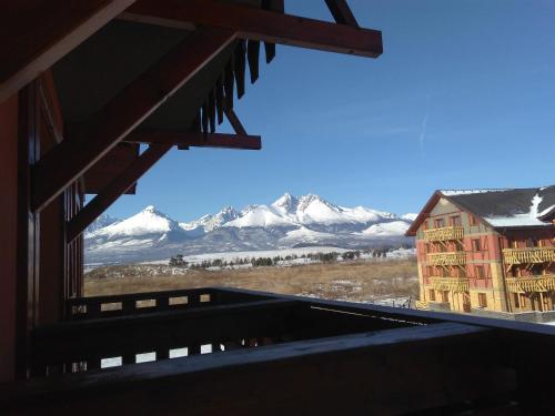 a view of snow covered mountains from a window at Apartmán Fiona in Veľká Lomnica