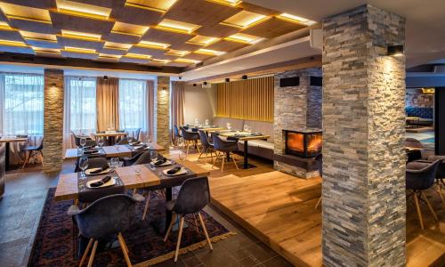 a dining room with tables and a fireplace at Vila 6aTo Hotel & Wellnes in Sofia