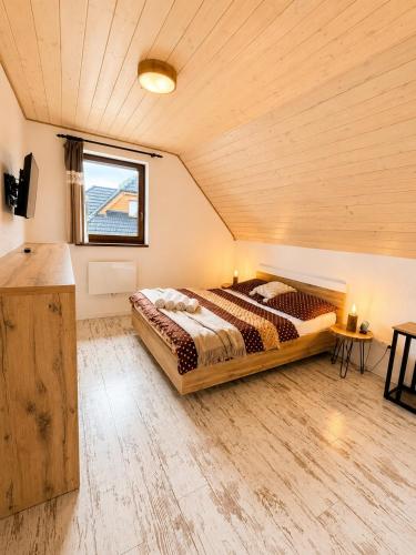 a bedroom with a bed in a room with a wooden ceiling at Vila Svistovka in Stará Lesná