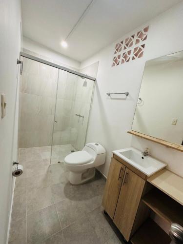 a bathroom with a toilet and a sink and a shower at Aluna Hotel, Laureles Medellín in Medellín