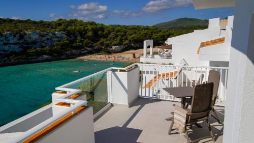 a balcony with a table and chairs overlooking a beach at Blau Punta Reina in Cala Mendia