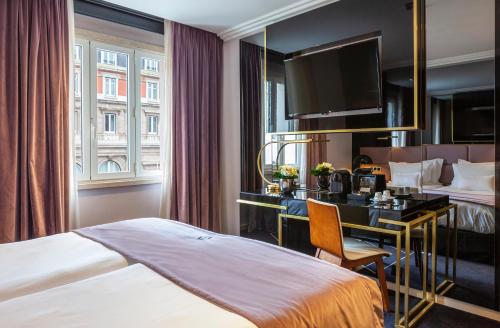 a hotel room with a bed and a desk at Altis Avenida Hotel, a member of Preferred Hotels & Resorts in Lisbon