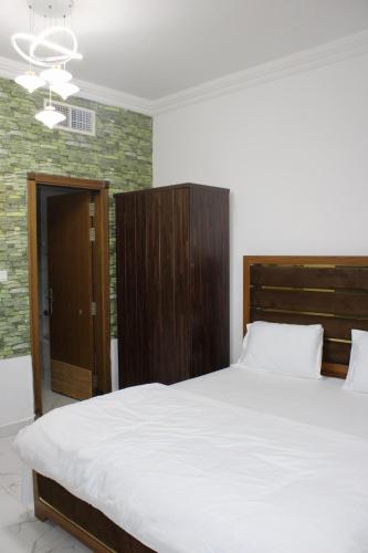 a bedroom with a large bed with a wooden headboard at Sea View Apartment with Balcony in Ajman 