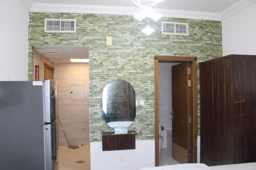 a room with a refrigerator and a stone wall at Sea View Apartment with Balcony in Ajman 