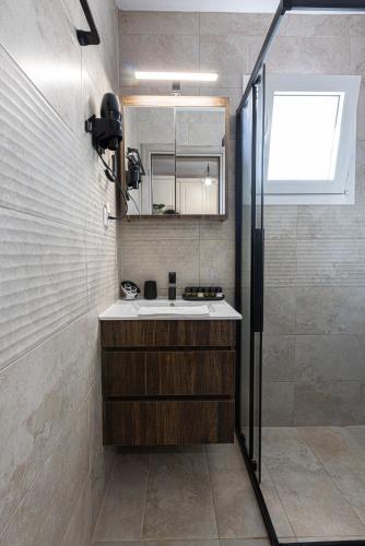 a bathroom with a sink and a shower at En Sophia Guesthouse in Maronia