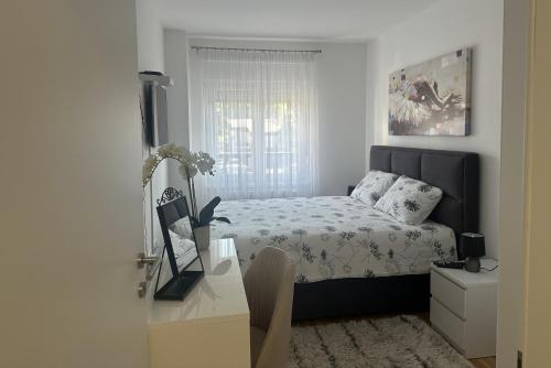 a bedroom with a bed and a desk with a television at Apartman IVANA - private parking in Osijek
