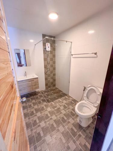 a bathroom with a toilet and a shower and a sink at พฤกษา วัลเลย์ รีสอร์ท in Ban Mak