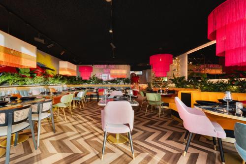 a restaurant with tables and chairs and pink lights at Resort Mooi Bemelen in Bemelen