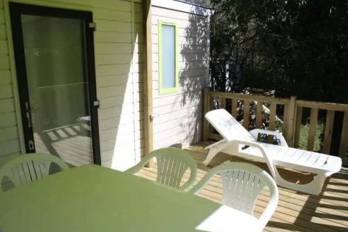 a patio with a table and chairs on a porch at Camping 3 étoiles - Piscine - ccbfhii in Bouzic