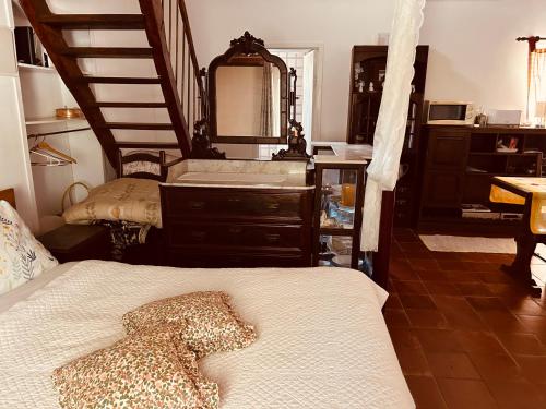 a bedroom with a bed and a staircase with a mirror at Mãe Home Carril in Caldas da Rainha