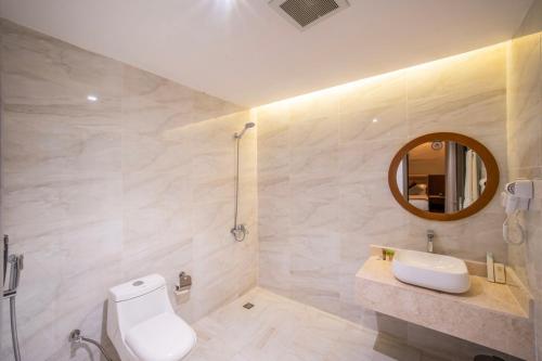 a bathroom with a toilet and a sink and a mirror at Nawara Dala - Economic in Riyadh
