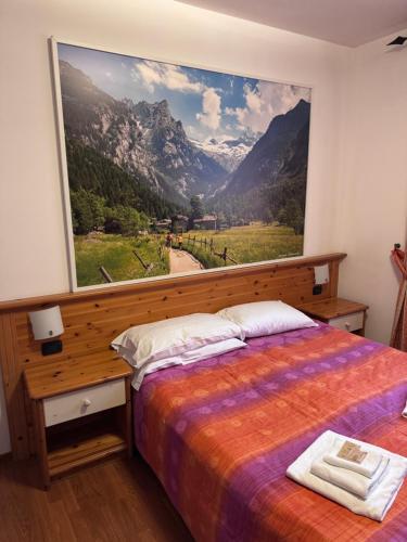 a bedroom with a large window with a mountain view at Hotel Culmine in Ardenno